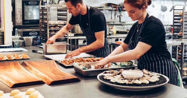 Two chefs working together in a professional kitchen, preparing gourmet dishes with precision.